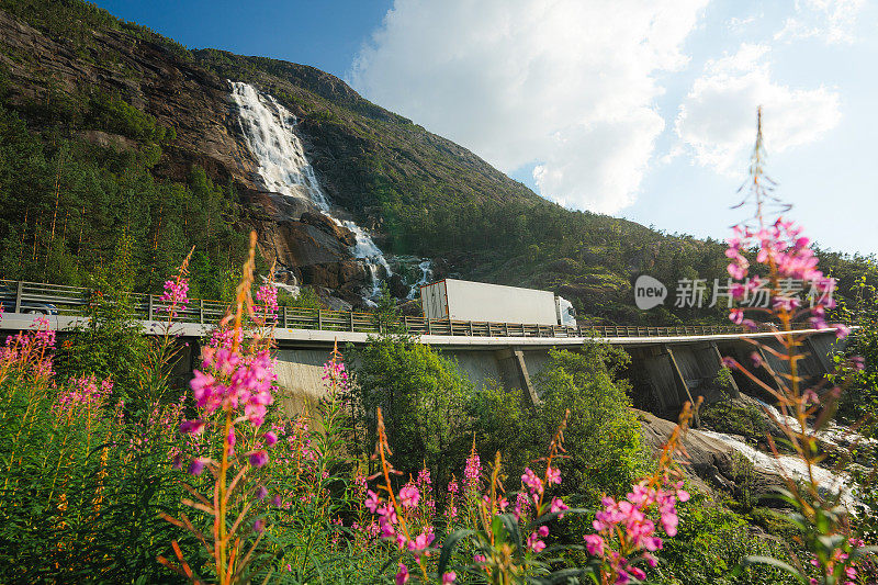 卡车行驶在挪威拉<s:1>特福森瀑布附近的道路上